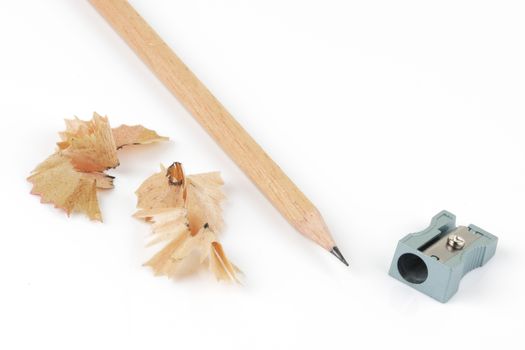 A top view of pencil and sharpener with shavings on white