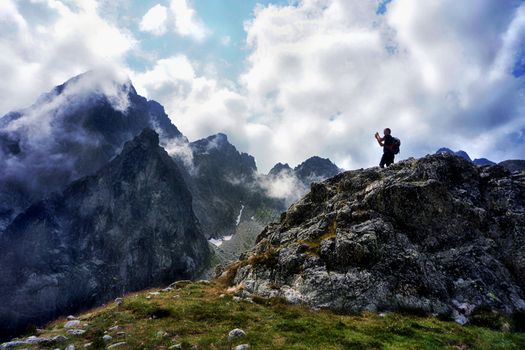 Man with hiking equipment walking in High Tatra mountain in Slovakia. Majestic View on the Lomnicky Stit in the background