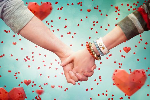 Students holding hands against love heart pattern