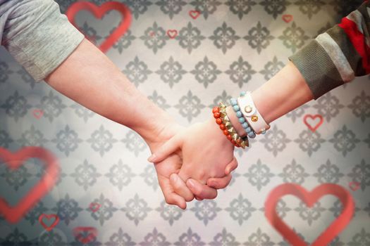 Students holding hands against love heart pattern