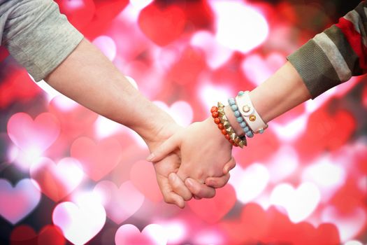 Students holding hands against valentines heart pattern