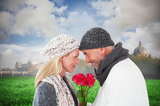 Smiling couple in winter fashion posing with roses against paris under cloudy sky