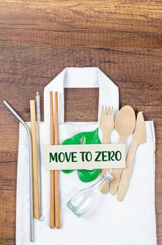 Move to Zero waste. Textile eco bags, wooden glass and bamboo utensil on wooden background. Eco friendly and reuse concept. Top view or flat lay