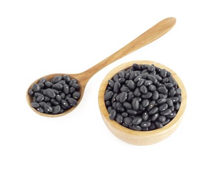 Closeup black beans seeds in wooden bowl on white background, healthy food concept