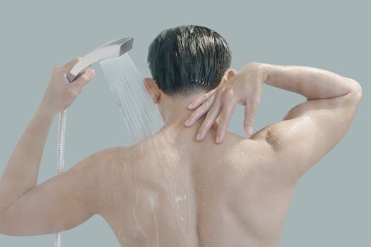 Closeup young man washing hair with with shampoo in the bathroom, vintage tone, selective focus