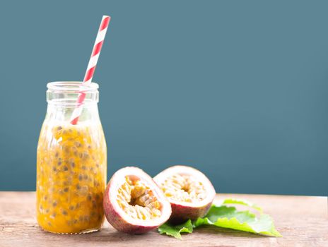 Glass bottle of passion fruit juice wood table isolated on grey background, food healthy concept