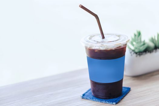 Closeup glass of ice americano on wood table in coffee shop
