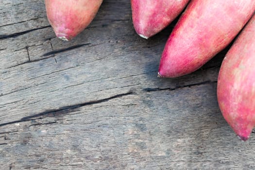 Raw sweet potato on wood table, healthy food concept