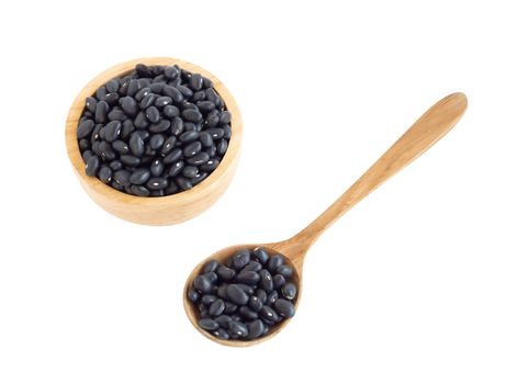 Closeup black beans seeds in wooden bowl on white background, healthy food concept