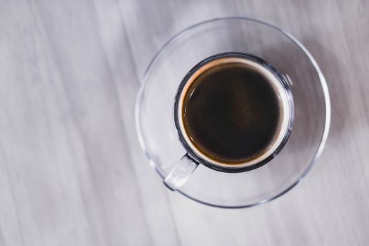 Closeup glass of hot americano coffee on wood table, selective focus, vintage tone