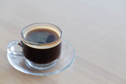 Closeup glass of hot americano coffee on wood table, selective focus, vintage tone