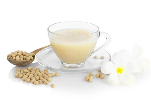 Soy milk in glass with soy beans in wooden spoon isolated on white background, health care concept