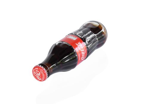 Sakon Nakhon, Thailand - April 29, 2020. Glass bottle of Coca-Cola isolated on white background