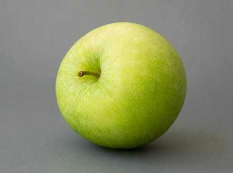 Closeup green apple on grey background, fruit for healthy diet concept
