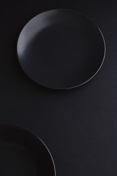 Empty plates on black background, premium dishware for holiday dinner, minimalistic design and diet concept