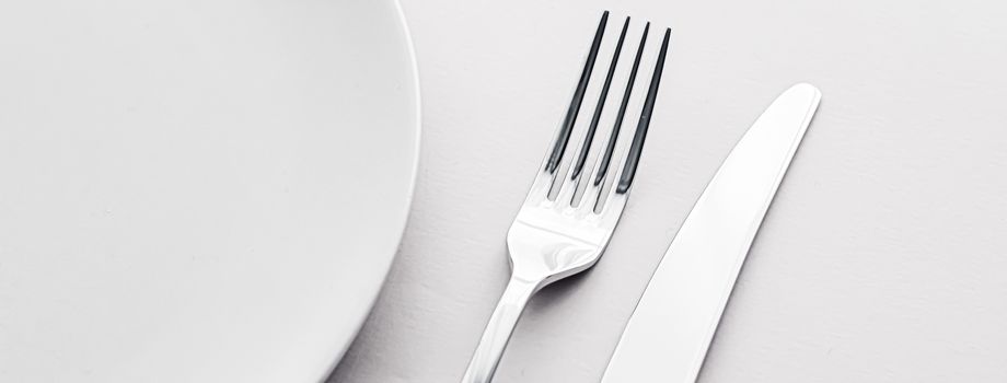 Empty plate and cutlery as mockup set on white background, top tableware for chef table decor and menu branding design