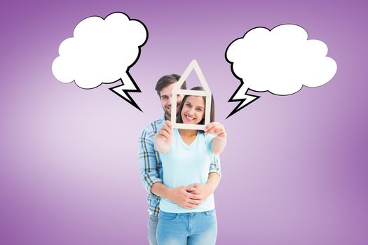 Happy young couple with house shape against purple vignette