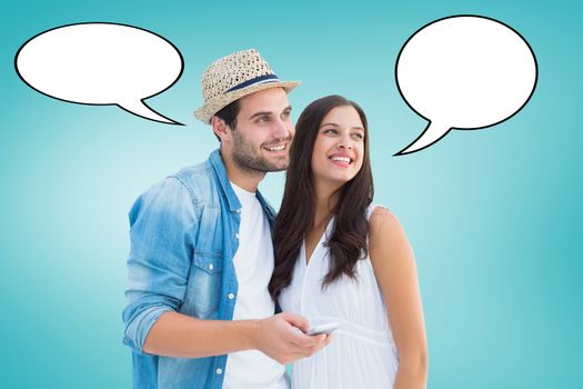 Happy hipster couple smiling together against blue vignette background