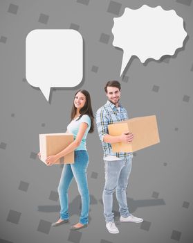 Happy young couple with moving boxes against grey