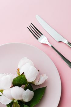 Dining plate and cutlery with peony flowers as wedding decor set on pink background, top tableware for event decoration and menu branding design