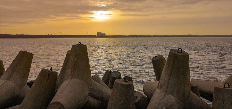 Sunset over baltic sea and coast of Swinoujscie city seen from breakwater