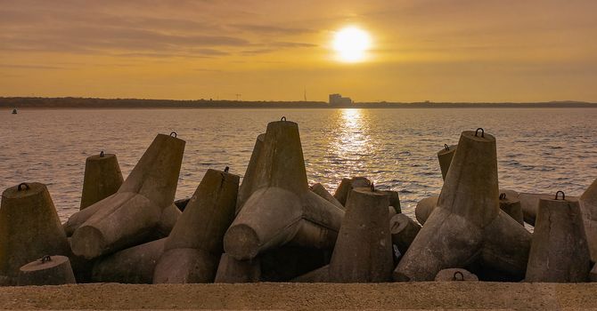 Sunset over baltic sea and coast of Swinoujscie city seen from breakwater