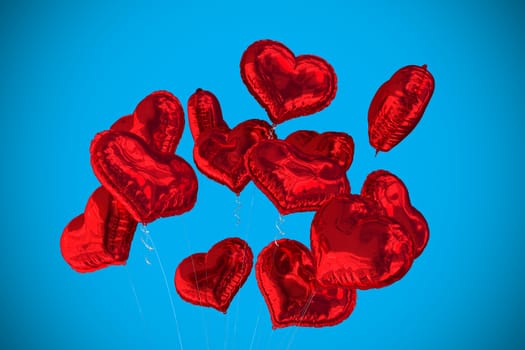 Heart balloons against blue background with vignette