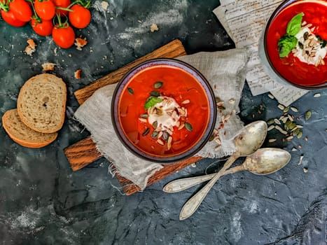 Flat lay of tomato soup with paper notes, bread, old spoons and cherry tomatoes