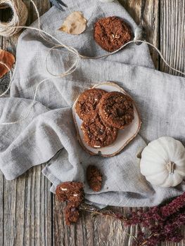 Flat lay of Chocolate cookies on wooden plate on white cloth