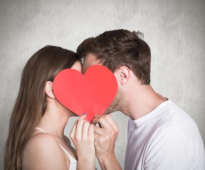 Side view of romantic couple holding heart against weathered surface 