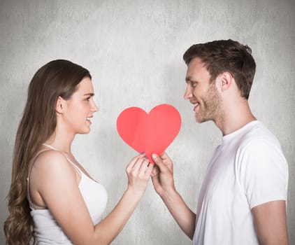 Romantic young couple holding heart against weathered surface 