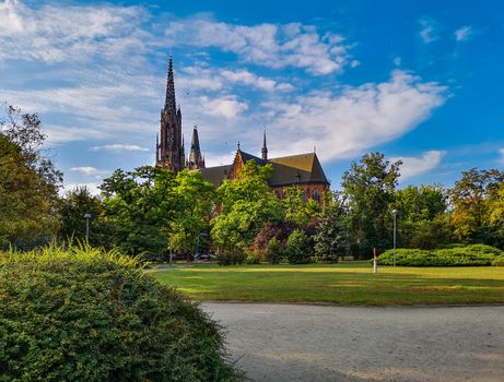 Green park of Saint Edith Stein with old cathedral in background