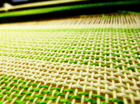 Weaving the fabric in the process. Interlacing of threads. Handwork, handicrafts, craft. Close-up