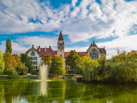 Lake in center of Wroclaw Tolpa Park with fountain in center with faculty of architecture of Wroclaw University