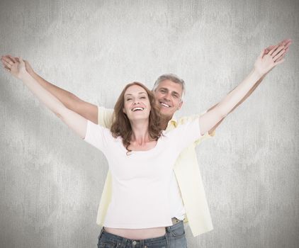Casual couple smiling with arms raised against white background