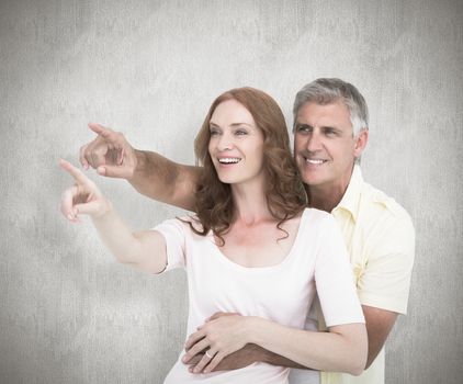 Casual couple smiling and pointing against white background