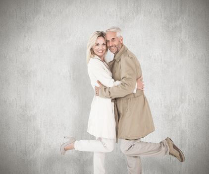 Happy couple posing in trench coats against white background
