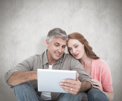 Casual couple sitting using tablet against white background