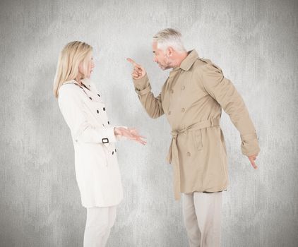 Angry couple fighting in trench coats against white background
