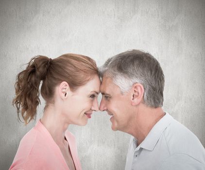 Casual couple smiling at each other against white background