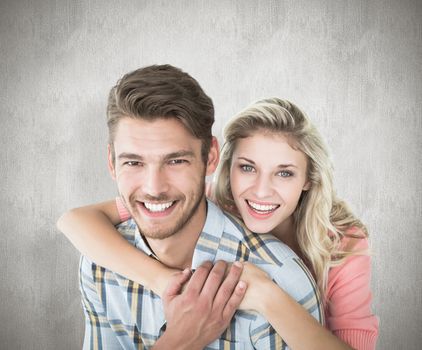 Attractive couple embracing and smiling at camera against white background