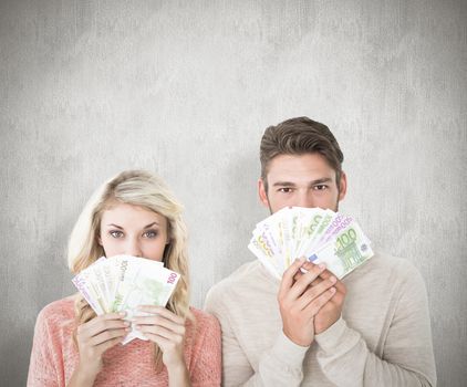 Attractive couple flashing their cash against white background