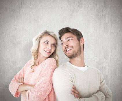 Attractive couple smiling with arms crossed against white background