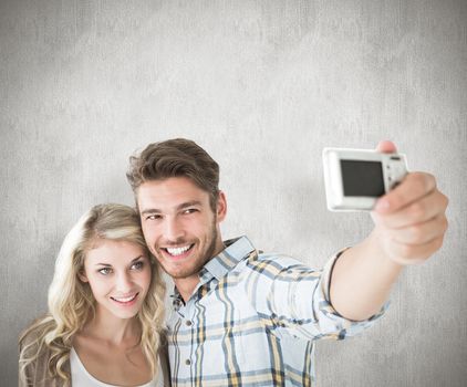 Attractive couple taking a selfie together against white background