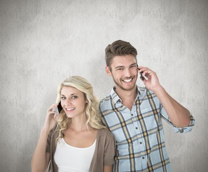 Attractive couple talking on their smartphones against white background