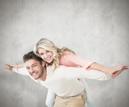 Handsome man giving piggy back to his girlfriend against white background