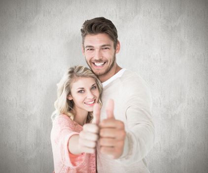 Attractive couple showing thumbs up to camera against white background