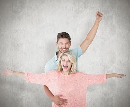 Attractive couple smiling and cheering against white background