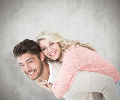 Handsome man giving piggy back to his girlfriend against white background