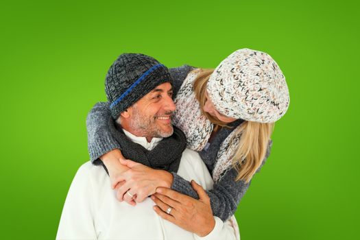 Happy couple in winter fashion embracing against green vignette